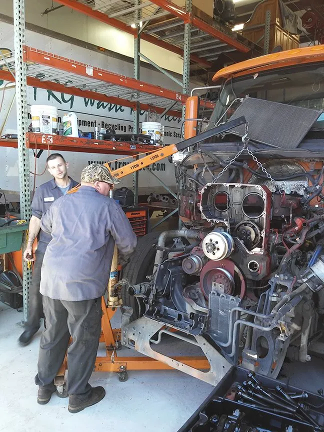 Two mechanics working on a truck engine